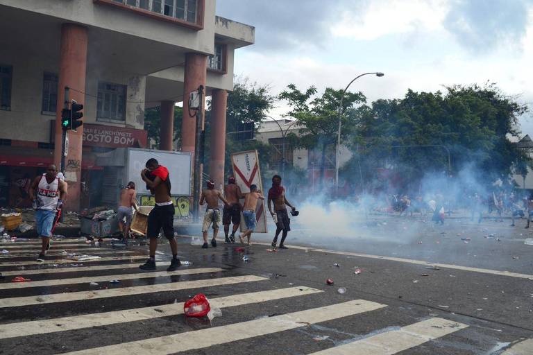 Flamenguistas correm no meio da rua para escapar da confusão no centro do Rio