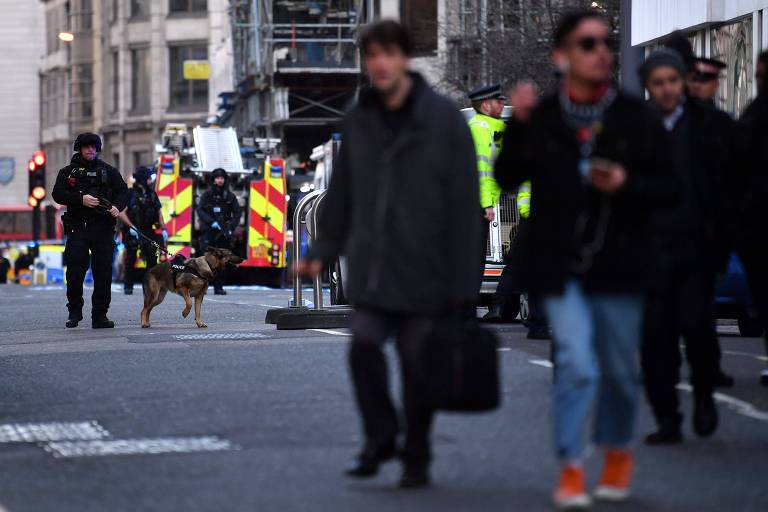 Pessoas deixam área enquanto policiais com cães patrulham rua na área central de Londres