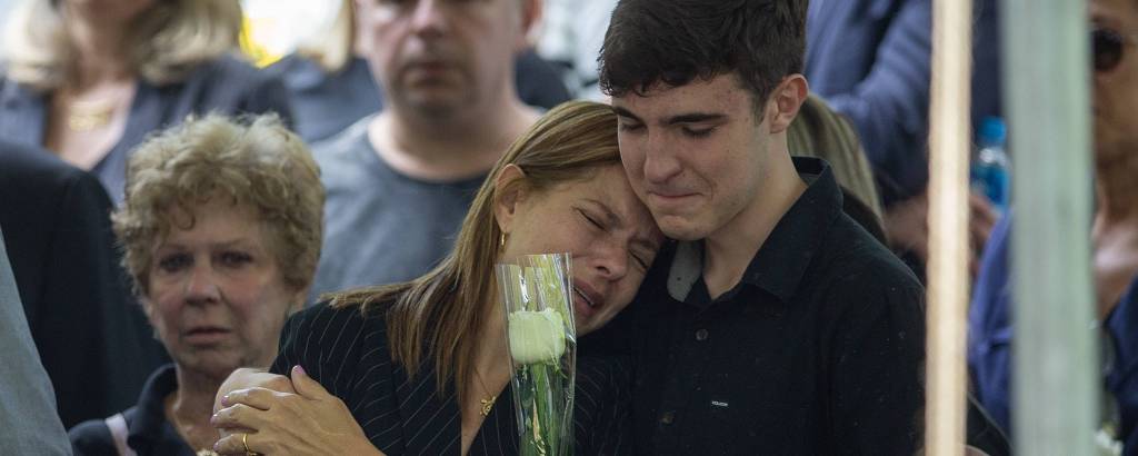 João Augusto Liberato ampara a mãe, Rose Miriam, no enterro do pai, Gugu