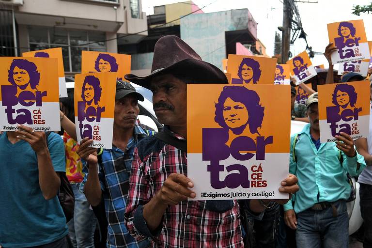 Ativistas seguram cartazes com a foto de Berta Cáceres durante audiência judicial de um dos suspeitos em Tegucigalpa, Honduras
