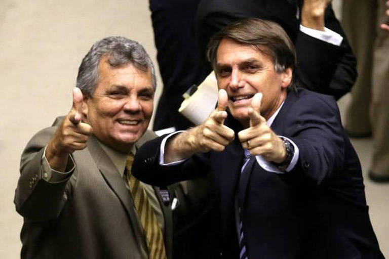 O presidente Jair Bolsonaro e o deputado eleito Alberto Fraga (PL-DF) fazendo com as mãos o símbolo de uma arma Crédito Reprodução / Arquivo Pessoal.