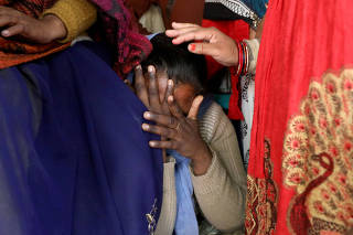 FILE PHOTO: A relative of a 23-year-old rape victim, who died in a New Delhi hospital on Friday after she was set on fire by a gang of men, which included her alleged rapists, is consoled as she mourns the death of the victim outside a house in Unnao