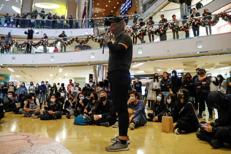 Ativista discursa durante ato relâmpago no shopping Taikoo, em Hong Kong