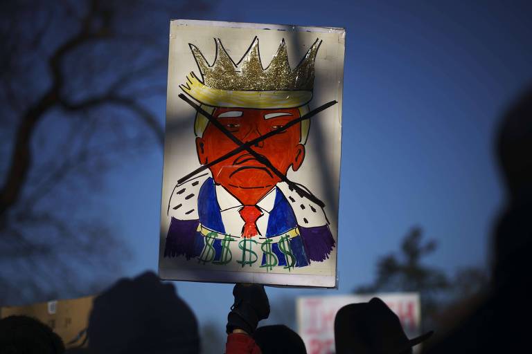 Manifestantes carregam cartaz contra Donald Trump em ato em frente ao Capitólio a favor do impeachment do presidente americano 