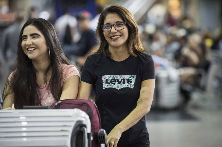 Tatiana Rêgo, 45, e a filha Gabriela,16, caminham no terminal 2 de Cumbica