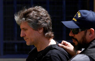 Former Argentine Vice President Amado Boudou is escorted by a member of Argentina's Coastguards as he arrives to a Federal Justice building in Buenos Aires
