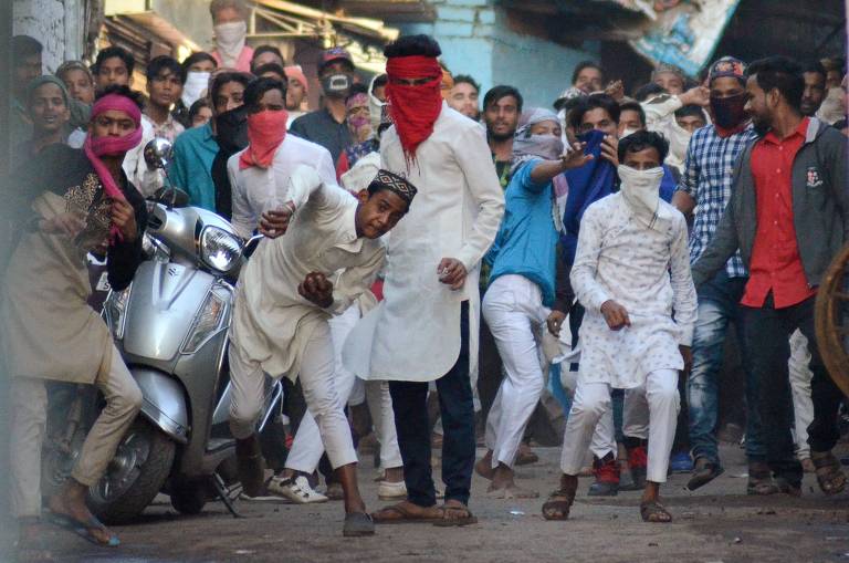 Manifestantes jogam pedras em protesto em Jabalpur, na Índia