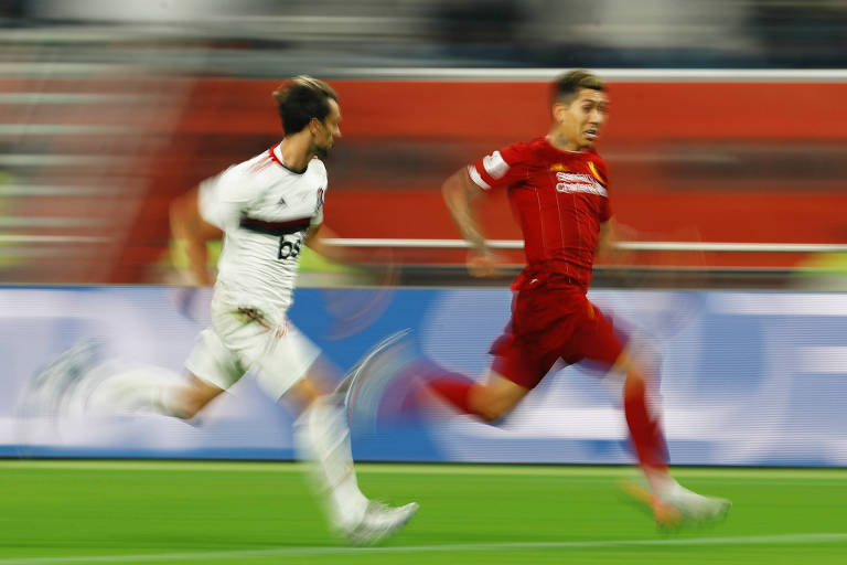 Rodrigo Caio, do Flamengo, e Roberto Firmino, do Liverpool, disputam a bola correndo na final do Mundial
