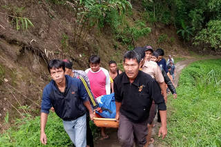 Rescue workers carry body of passenger of Sriwijaya bus following accident at Liku Lematang, South Sumatra