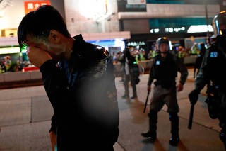 A man who got pepper sprayed by riot police reacts during an anti-government protest on Christmas day in Hong Kong