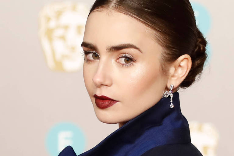 Pele iluminada é a aposta da make de Lily Collins combinada ao batom vermelho