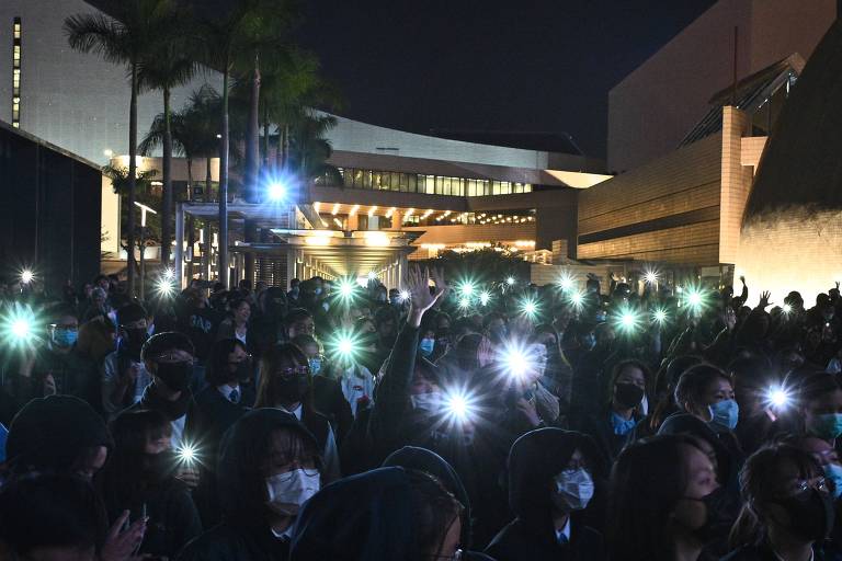 Estudante com luzes de telefones celulares durante protestos pró-democracia em Hong Kong