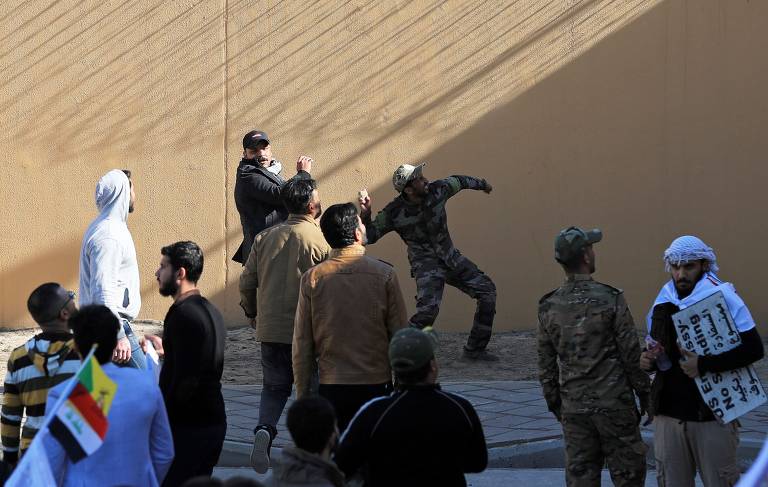 Manifestante joga pedra contra a embaixada dos EUA em Bagdá, no Iraque
