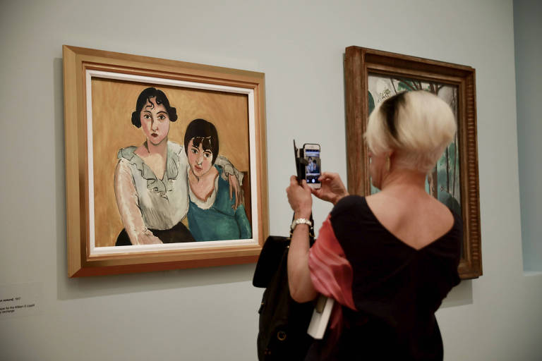 Mulher fotografando obra de arte na Galería Nacional de Australia, em Canberra, Australia