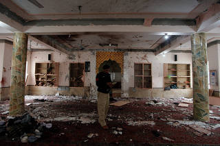 A police officer stands amidst the damages as he is surveying and collecting evidence from the site of a bomb blast in a mosque in Quetta,