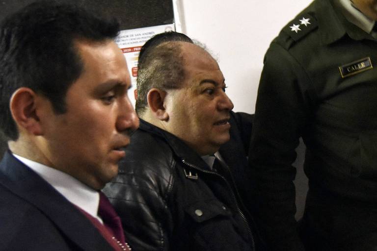 O ex-ministro Carlos Romero é escoltado por policiais em La Paz