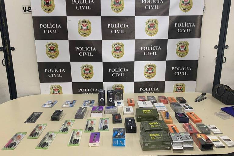 Mesa da Policia Civil com embalagens de diferentes marcas e modelos de cigarros eletrônicos 