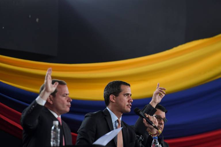 Juan Guaidó (centro) com bandeira venezuelana atrás