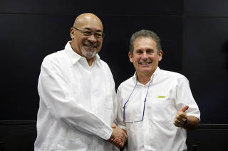 Suriname's President Desi Bouterse and Rudolf Elias, director of Suriname's state-owned oil company Staatsolie, shake hands after a news conference announcing that Apache Corporation and Total made a major oil discovery offshore Suriname, in Paramaribo