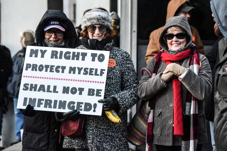 Mulheres exibem cartaz com a frase: "Meu direito de me defender não será violado"