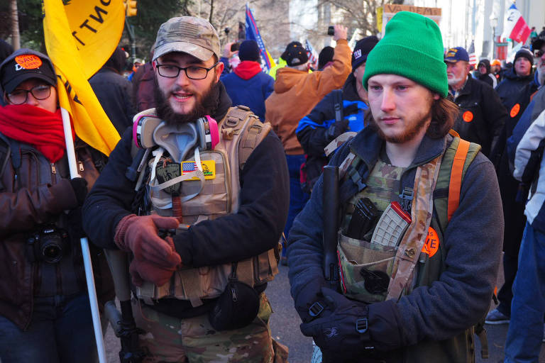 David Johnson (à esq.), 22, quer "armas para proteger o povo da tirania dos governantes; Levi Clark (capuz verde), 23, viajou mais de oito horas a partir de Ohio para viver "um momento muito importante"
