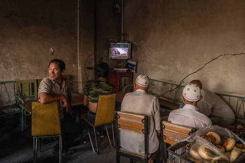 Uighur men watch a movie at a tea house in Yarkand, in the Xinjiang region of China, on Aug. 8, 2019. The ancient Muslim town is a cultural cradle for the Uighurs, who have experienced mass detentions. A rare visit revealed how people there have endured the upheavals. (Gilles Sabrié/The New York Times) ORG XMIT: XNYT21