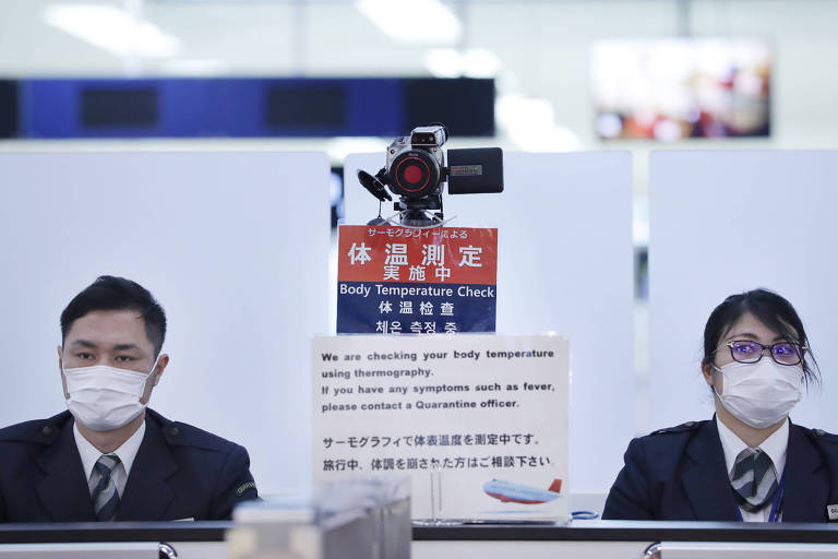Funcionários japoneses fazem rastreamento de passageiros que chegam de Wuhan, China, por causa da ameaça do coronavírus; uma pessoa foi infectada no Japão