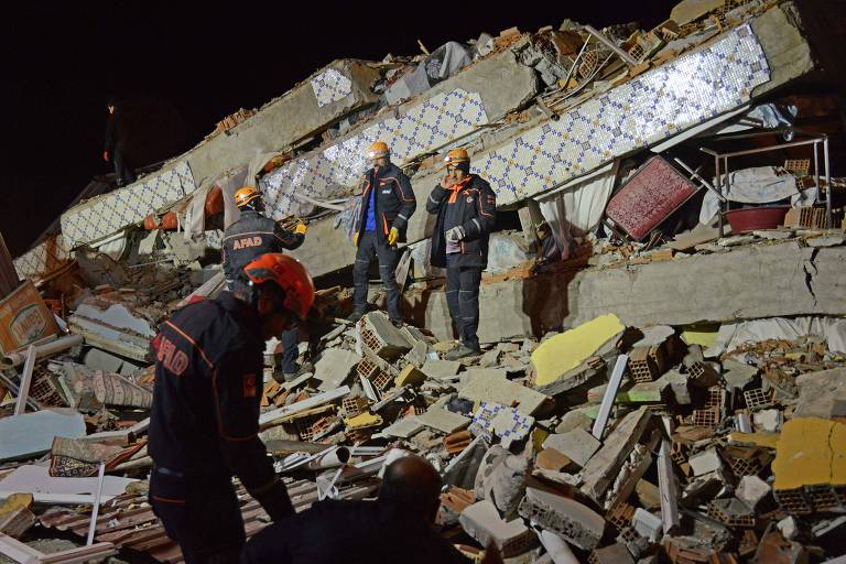 Membros das equipes de resgate em local onde prédio ruiu após terremoto em Elazig, na Turquia