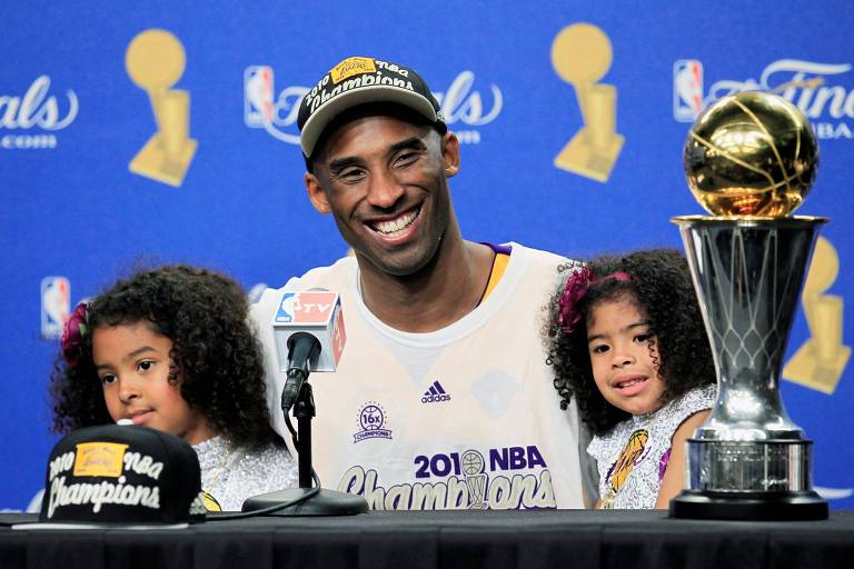 Kobe com suas filhas Gianna e Natalia, ao lado do troféu de melhor jogador da NBA 