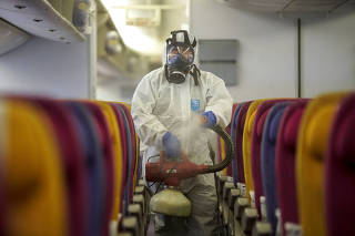 A member of the Thai Airways crew disinfects the cabin of an aircraft of the national carrier during a procedure to prevent the spread of the coronavirus at Bangkok's Suvarnabhumi International Airport