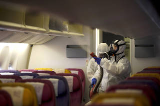 Members of the Thai Airways crew disinfect the cabin of an aircraft of the national carrier during a procedure to prevent the spread of the coronavirus at Bangkok's Suvarnabhumi International Airport