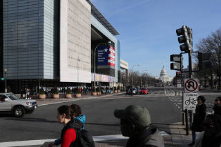 People walk near the Newseum during its last week of operation before closing in Washington