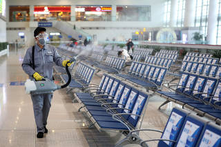 Workers in protective mask disinfects a waiting hall following the outbreak of a new coronavirus at the Nanjing Railway Station, in Nanjing, Jiangsu