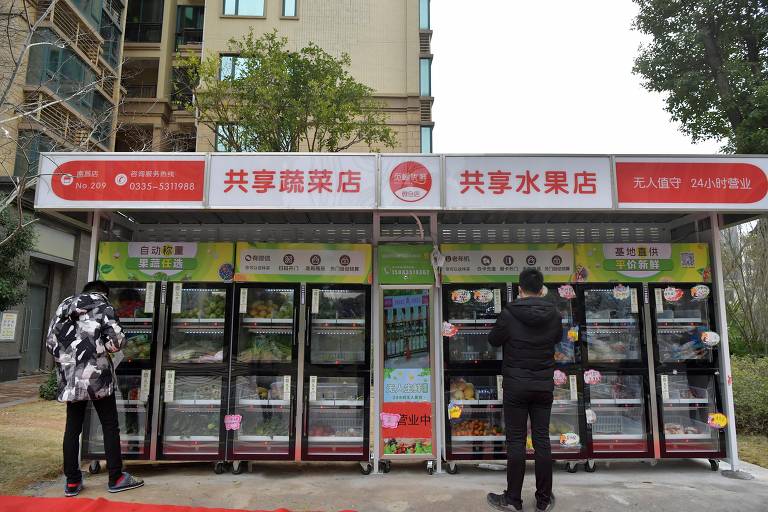 Moradores compram vegetais em uma tenda em comunidade de Nanchang, na província de Jiangxi, que tem 109 infectados