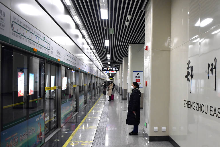 Mulher em estação vazia de metrôs em Zhengzhou, província de Henan