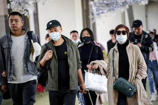 Passengers arriving from Guangzhou, China, wear masks at the Ninoy Aquino International Airport in Pasay