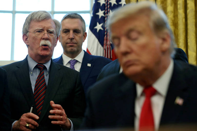 O presidente Donald Trump, à dir., escuta o hoje ex-assessor de Segurança Nacional John Bolton falar durante evento no Salão Oval