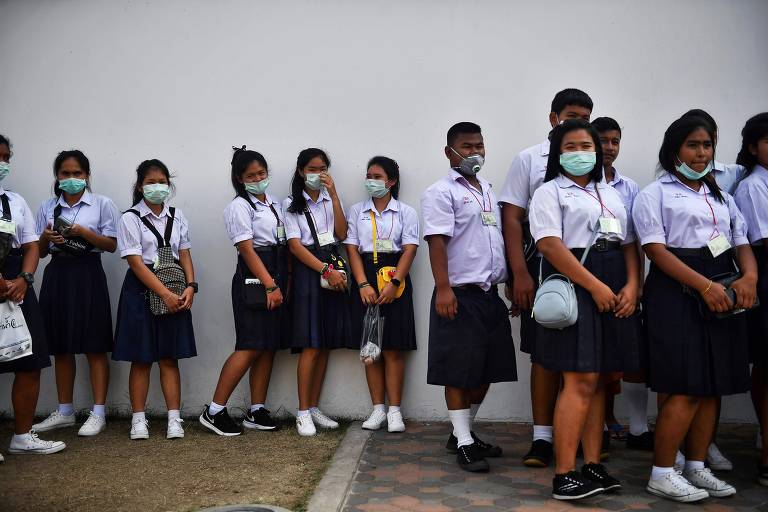 Estudantes tailandeses usando máscaras em frente ao Grand Palace, em Bangcoc, em 29 de janeiro de 2020