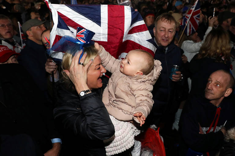 Mulher com bebê no meio da festa na praça do Parlamento, em Londres 