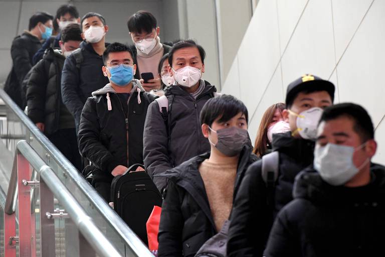 Passageiros vestem máscaras na Estação Ferroviária de Zhengshou Leste, na província de Henan, no centro da China