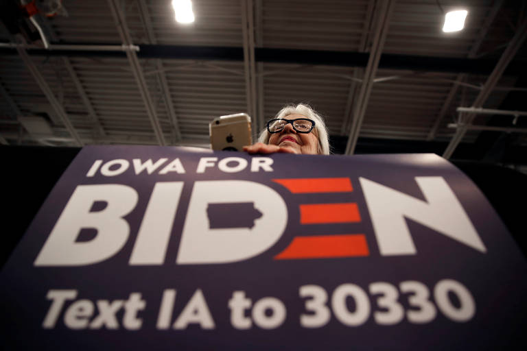 Apoiadora exibe cartaz do ex-vice-presidente e candidato Joe Biden em Des Moines, Iowa