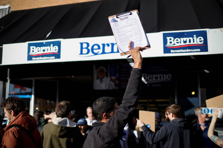 Voluntários coletam assinaturas para candidato Bernie Sanders na porta do comitê de campanha em Newton, Iowa