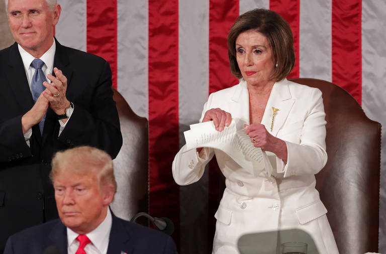 Presidente da Câmara, a democrata Nancy Pelosi rasga uma cópia do discurso a poucos metros de Donald Trump