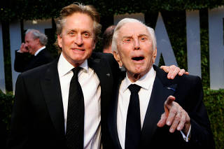 FILE PHOTO: Actor Michael Douglas and his father, actor Kirk Douglas, arrive together at the 2009 Vanity Fair Oscar Party in West Hollywood, California