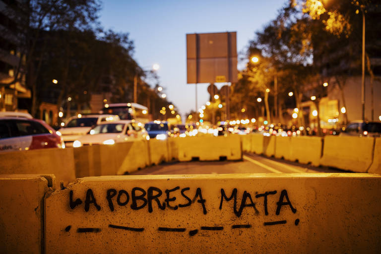 Pixação com a inscrição "La pobresa mata" em rua de Barcelona, na Espanha