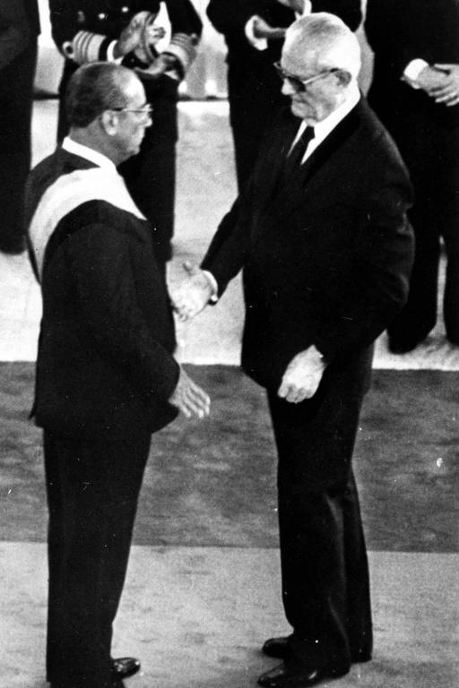O general e presidente Ernesto Geisel (à dir.) passa a faixa presidencial  ao general Figueiredo durante cerimônia de posse. De fato, Figueiredo foi escolhido a dedo por Geisel para sucedê-lo e dar continuidade ao processo de abertura política iniciado em seu governo
