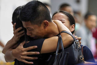 Son and daughter of Captain Siriwiwat Sangprasita, a victim of a gun battle involving a Thai soldier on a shooting rampage, cry after seeing his dead body at a hospital in Nakhon Ratchasima