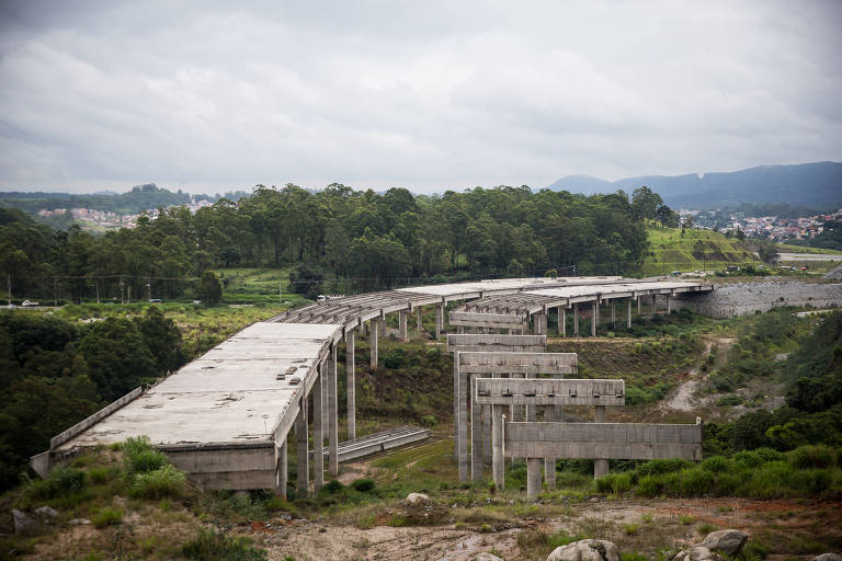 Imagem mostra estrutura de viaduto da Rodoanel, inacabado, e em meio à vegetação.