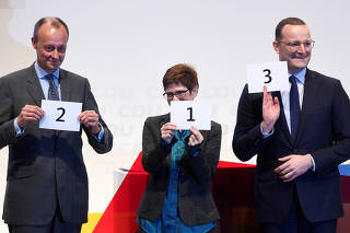 FILE PHOTO: Christian Democratic Union (CDU) candidates Merz, Kramp-Karrenbauer and Spahn show signs with numbers displaying the order of their speeches at a regional conference in Luebeck