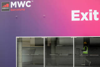 Employee walks near the Logo of MWC20 (Mobile World Congress) in Barcelona